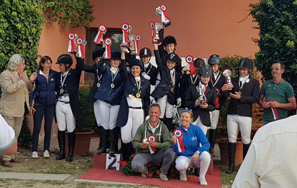 Gran festa a Mondovì ai Piemontesi, I Campionati Regionali di Dressage si sono conclusi con la Medaglia d'Oro nel Campionato a squadre, dei "Bacchetta Kids", l'agguerrita squadra costituita dalla Scuderia San Giacomo con Rachele Maghini, Edoardo Zara ed il Centro Ippico Lasiria con Sofia Fonio e Anna Bellezza Rosati. Nella foto riconosciamo tra gli altri Marco Pittino oro Assoluto oltre ad Alessandro Poncino giudice e coordinatore dressage per il Piemonte, accovacciati gli istruttori Giorgio Bacchetta e Paola Lerma. (photo courtesy: Scuderia San Giacomo).